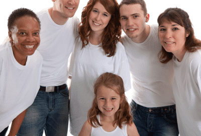 Group of people of all ages all wearing white T-shirts, representing orthodontics for all ages