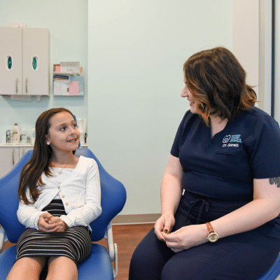 RPDO dental staff member talking to a little girl, representing orthodontic treatment for children