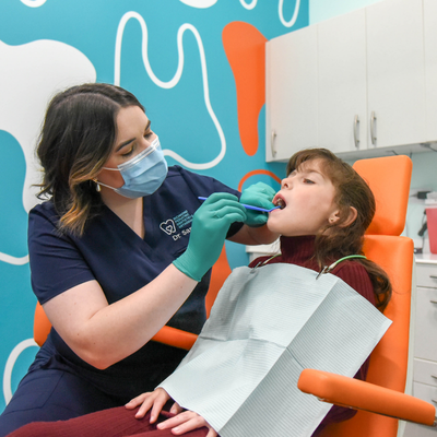 Dr. Yi gently examines a young patient during a dental visit at Richmond Pediatric Dentistry & Orthodontics, demonstrating Why National Children’s Dental Health Month Is Important for early preventive care and healthy smile development.