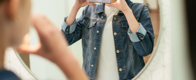 Teen orthodontic patient using the Dental Monitoring ScanBox and smartphone to take a weekly scan at home