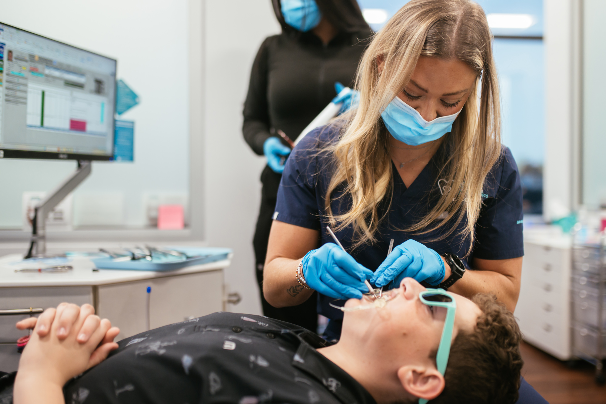 Orthodontist for Teens in Richmond, VA: Braces and Clear Aligners 2 Orthodontist for teens in Richmond adjusting a teen patient's braces