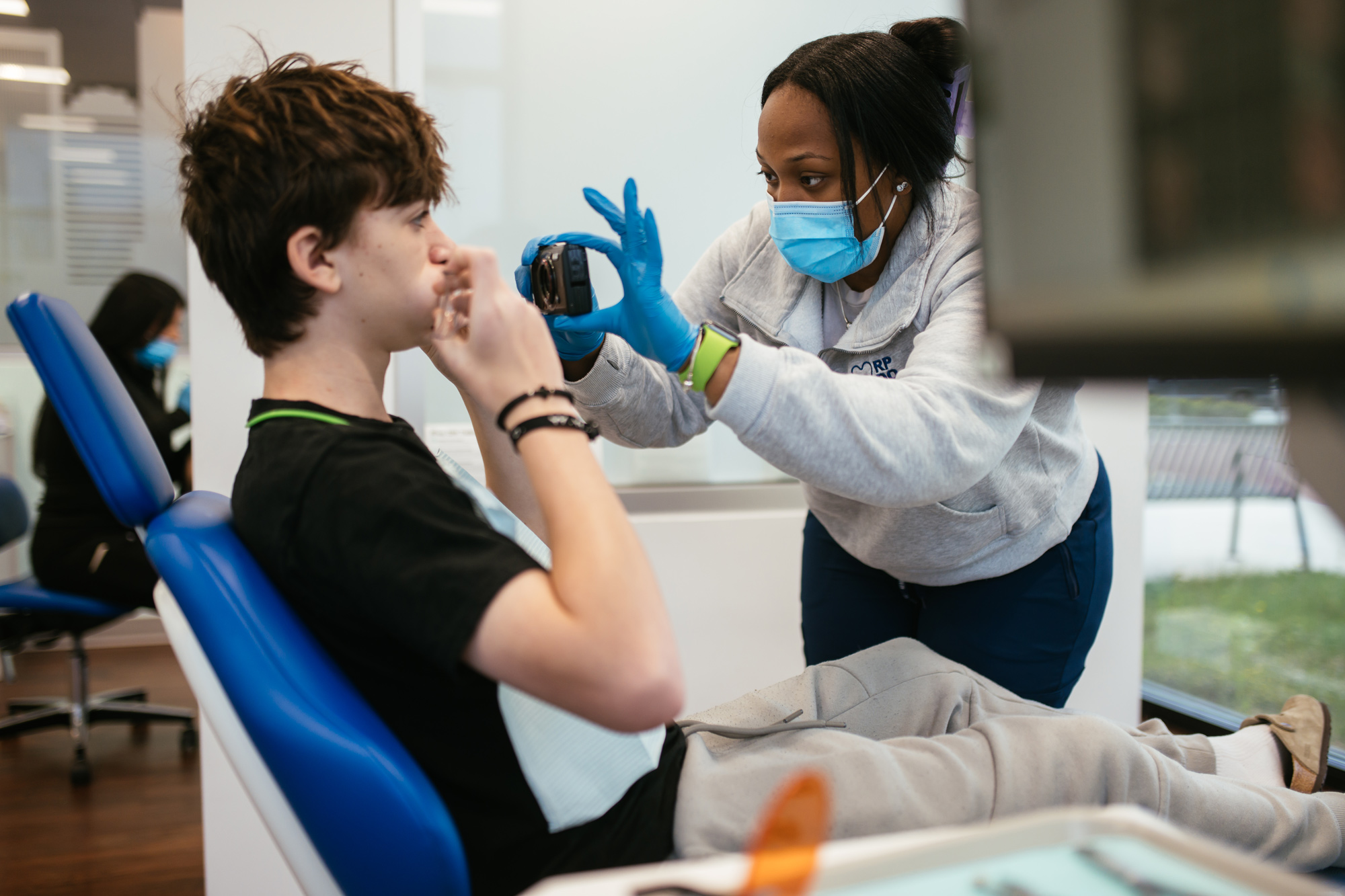 Orthodontist for Teens in Richmond, VA: Braces and Clear Aligners 4 RPDO orthodontic team member taking intraoral photos during a teen's first consultation in Richmond, VA