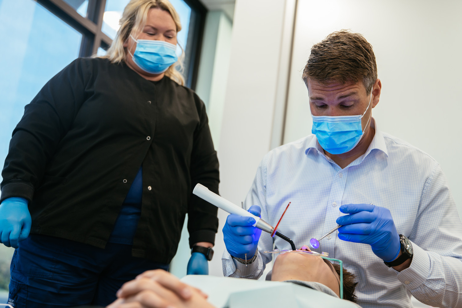 Orthodontist and dental assistant bonding braces with a curing light at RPDO in Richmond, VA
