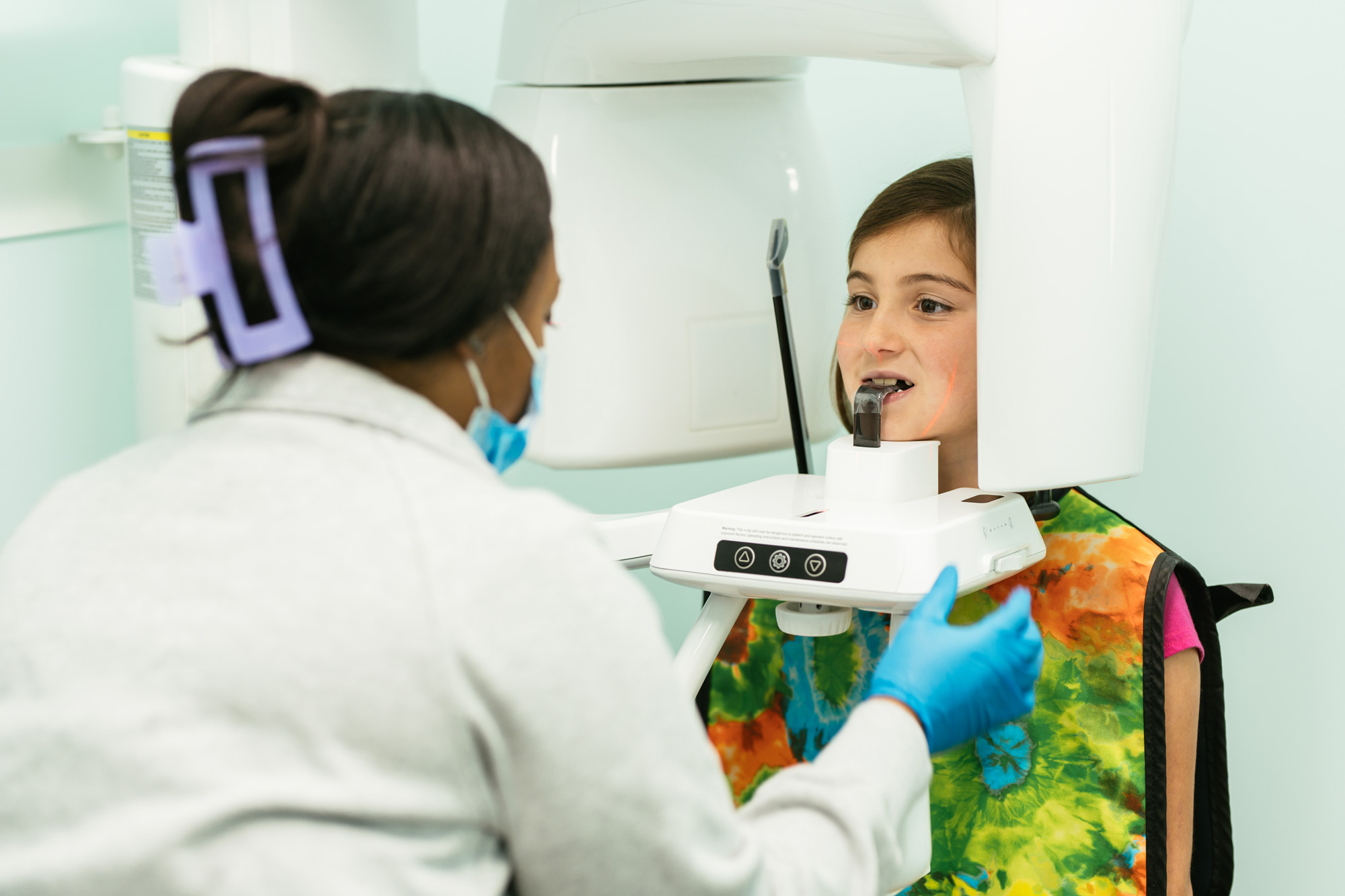 Young girl getting a panoramic dental X-ray during an early orthodontic evaluation at Richmond Pediatric Dentistry and Orthodontics