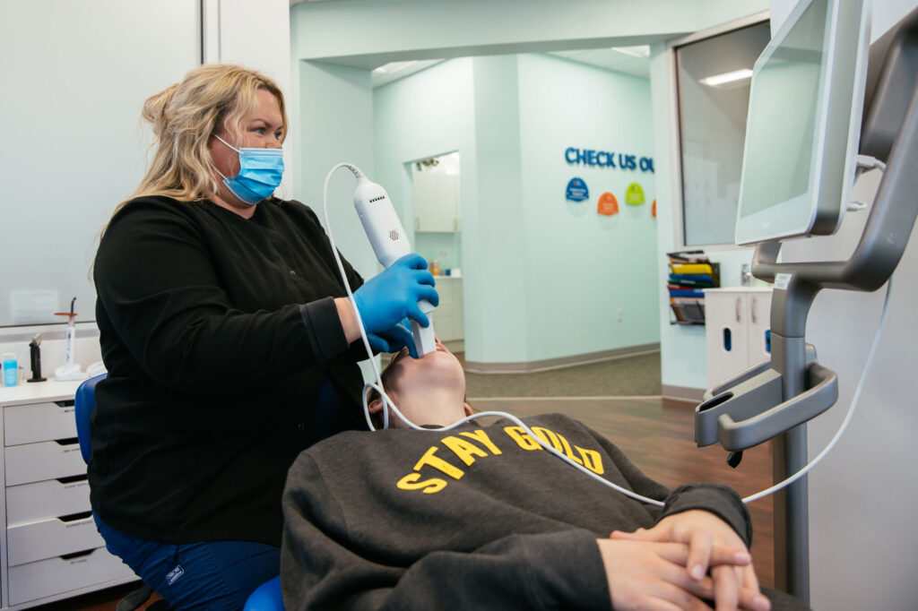 Location Richmond 4 RPDO orthodontic assistant taking a digital intraoral scan of a patient's teeth