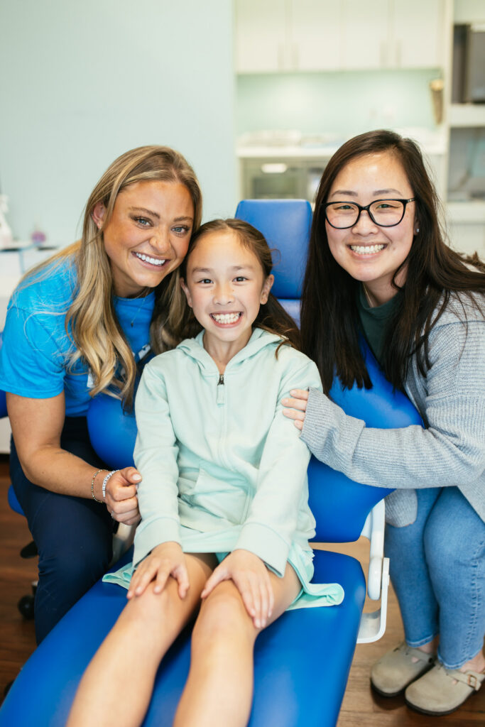 RPDO team members smile with a young patient in the exam chair at our Richmond, VA orthodontic office