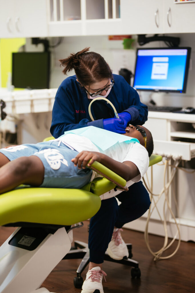 Pediatric hygienist gently cleaning a young patient's teeth at RPDO