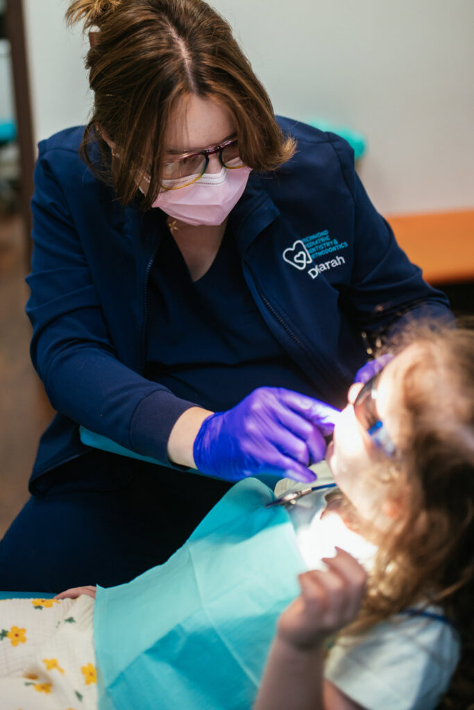 Dr. Sarah Yi, pediatric dentist at Richmond Pediatric Dentistry and Orthodontics, examining a toddler's teeth