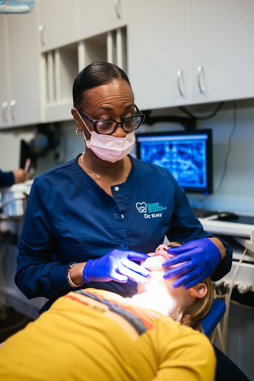 Dr. Ray performing a dental exam on a child at Richmond Pediatric Dentistry and Orthodontics, a kids dentist in Henrico County, VA