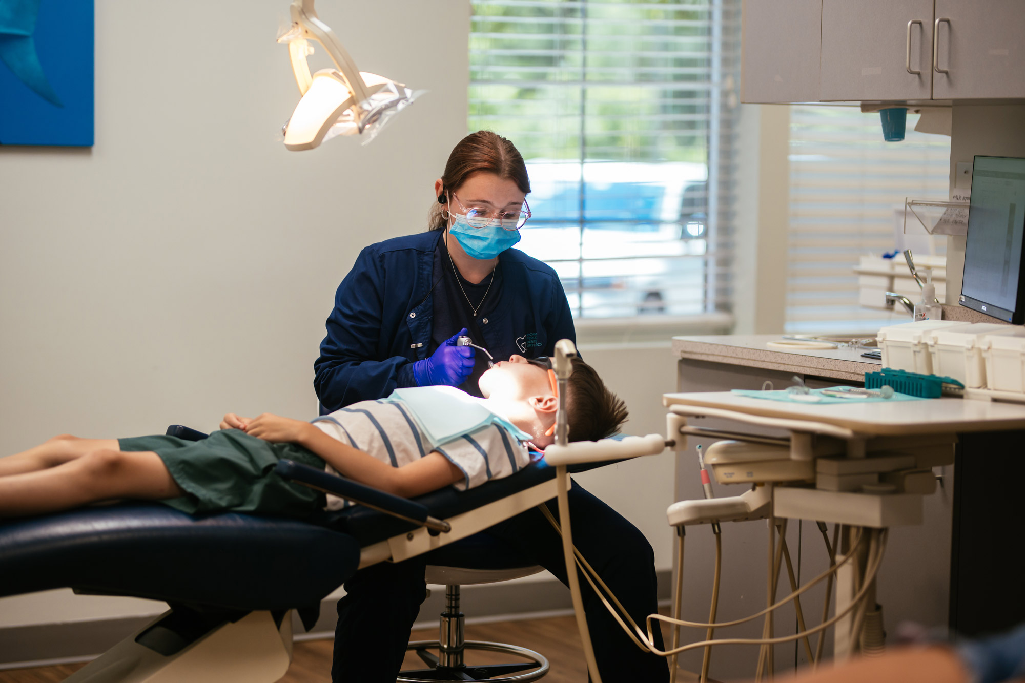 Pediatric dental team member polishing a young boy's teeth during a routine cleaning at Richmond Pediatric Dentistry & Orthodontics, serving Glen Allen VA families