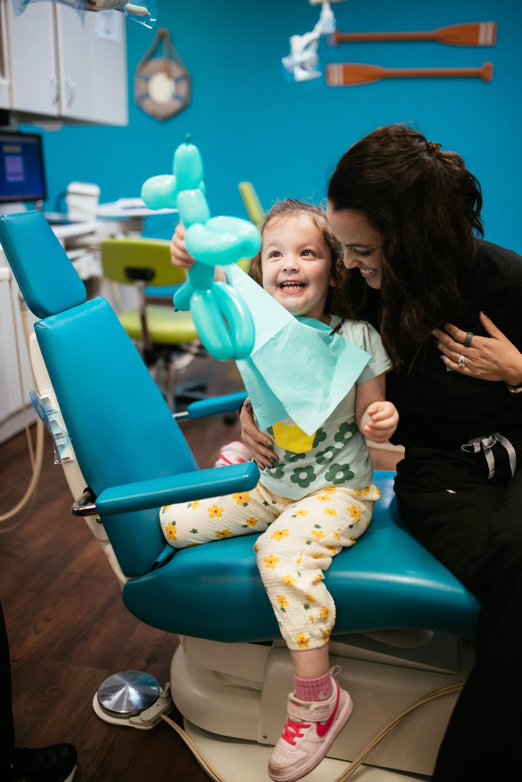 Smiling young patient holding a balloon animal in the dental chair at Richmond Pediatric Dentistry and Orthodontics, a pediatric dentist in Henrico County, VA