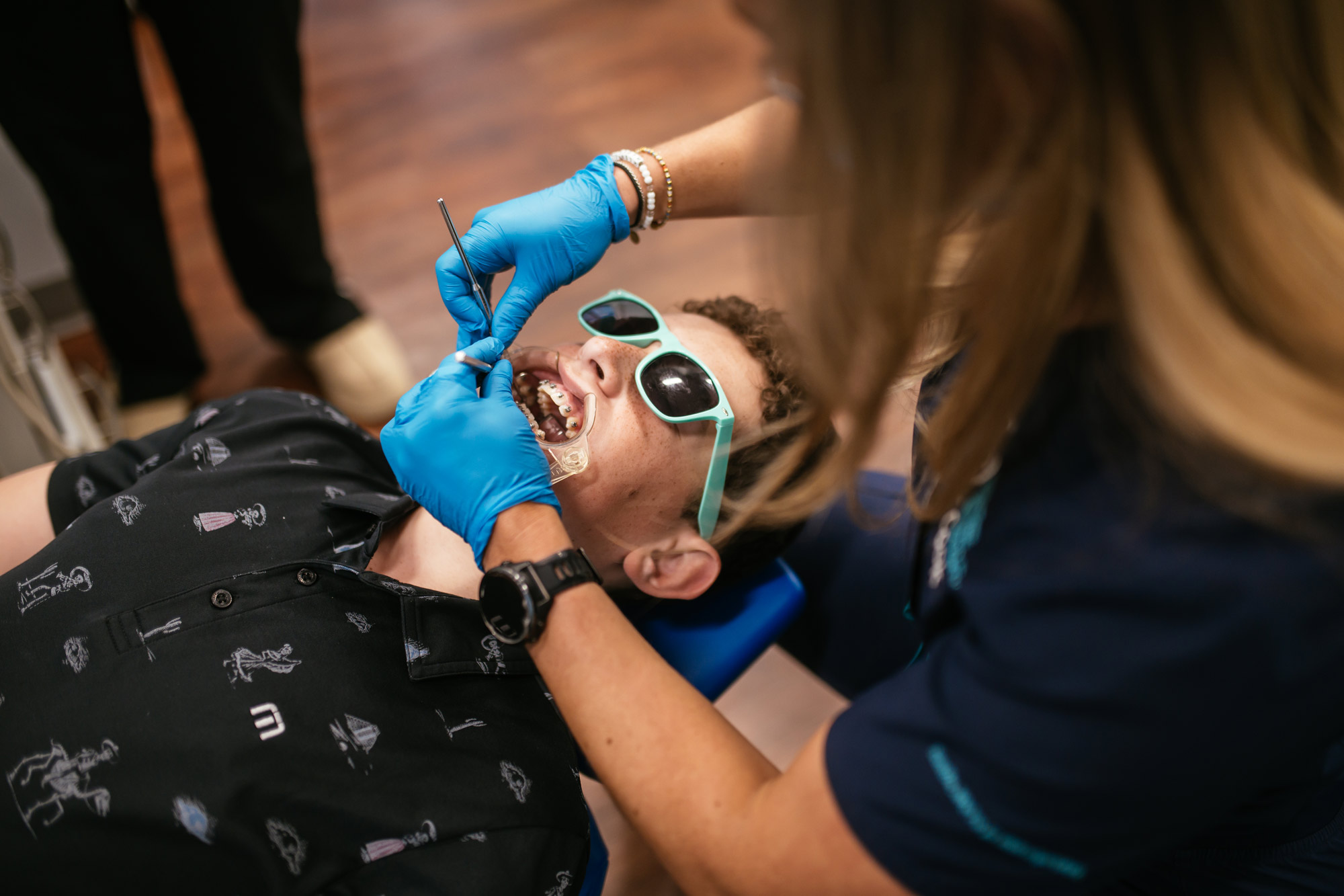 Orthodontic assistant adjusting braces for a teen patient at Richmond Pediatric Dentistry and Orthodontics in Richmond, VA