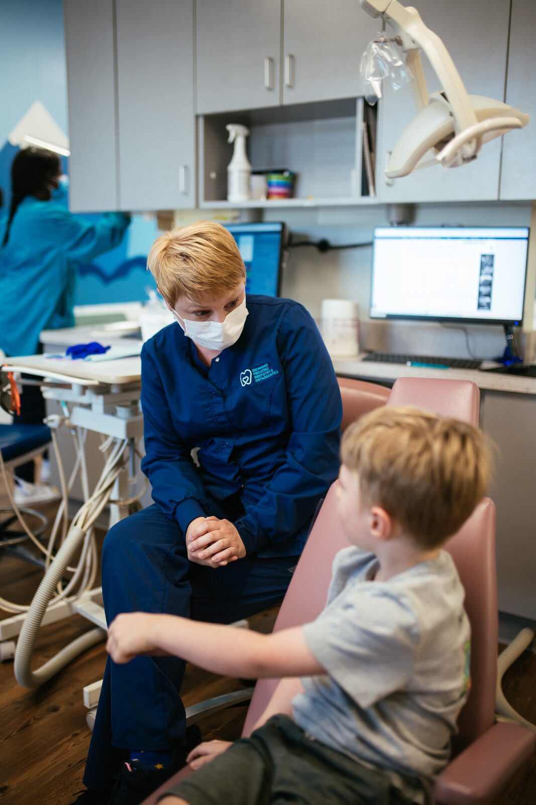 An RPDO team member talking with a child at eye level before an exam