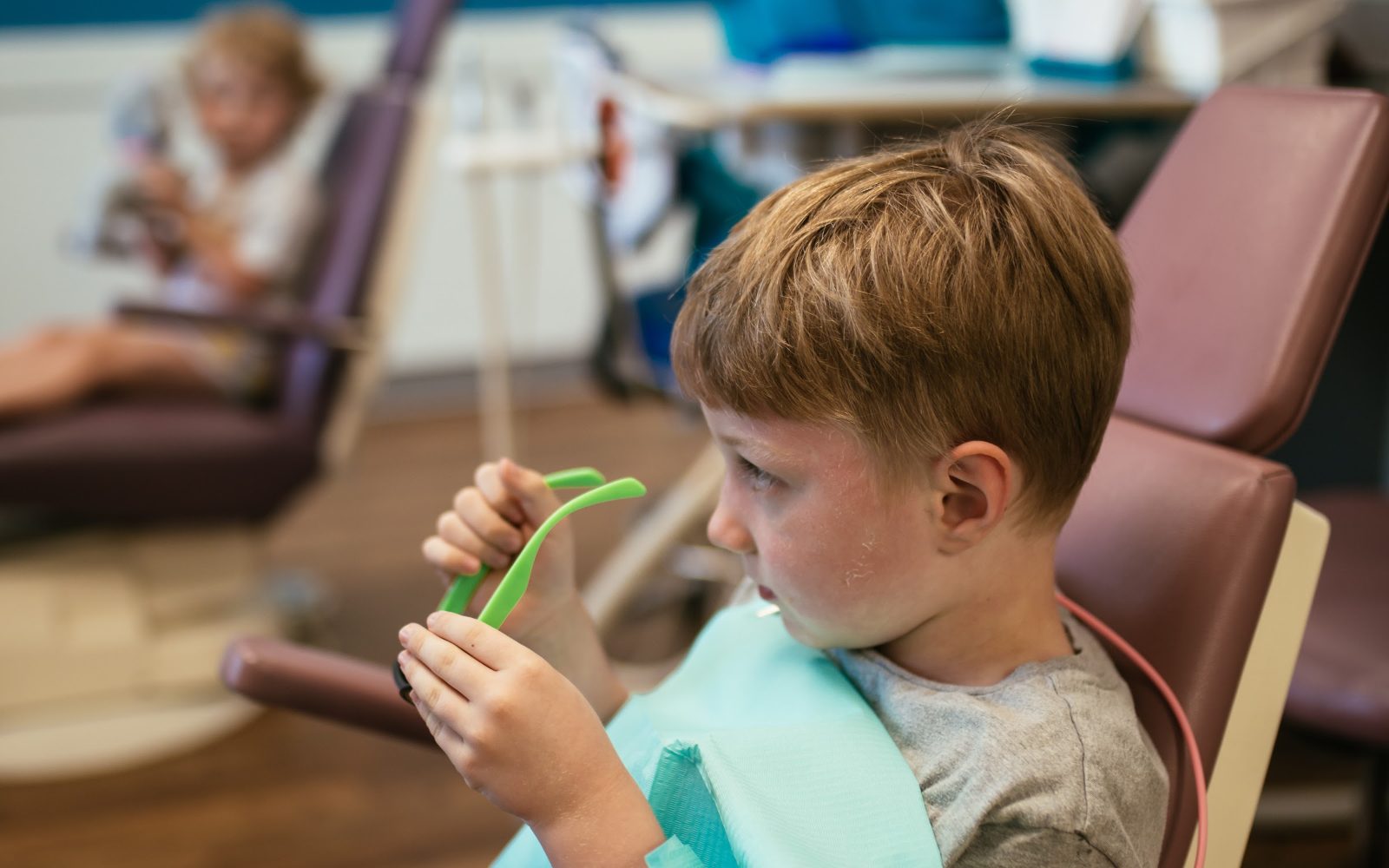 Teeth Cleaning for Kids in Richmond, VA 6 Preschooler holding a toothbrush in the dental chair at RPDO in Richmond, VA