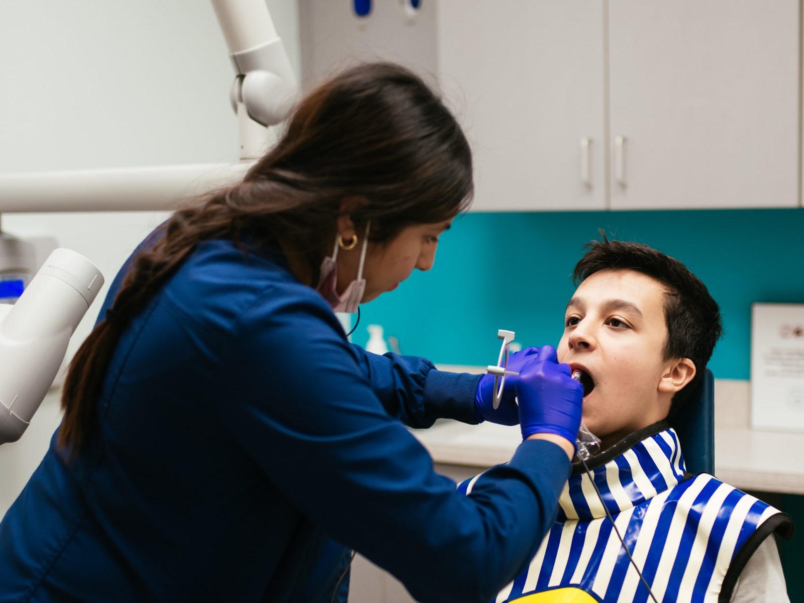 Teeth Cleaning for Kids in Richmond, VA 7 Hygienist removing plaque and tartar during a teen's dental cleaning at RPDO in Richmond, VA